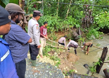 Polisi Bersama Masyarakat Mengevakuasi Jembatan Yang Putus Akibat Banjir