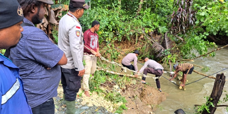 Polisi Bersama Masyarakat Mengevakuasi Jembatan Yang Putus Akibat Banjir