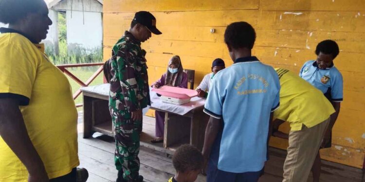 Babinsa Koramil 1710-01/Kokonao Dampingi Nakes Periksa Kesehatan Warga