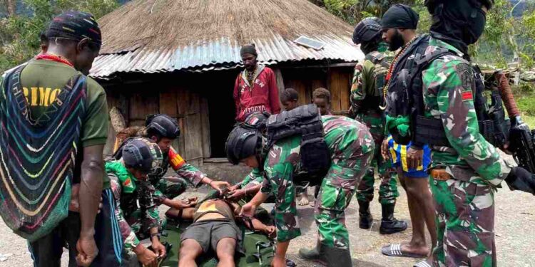 Disela Membangun Gudang Logistik BNPB, Prajurit Yonif 751/VJS Bantu Tandu Warga Sinak Berobat