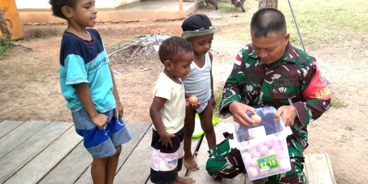 Momen Babinsa Berikan PMT Kepada Anak-Anak Distrik Elikobel